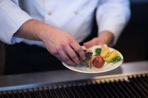 commercial grill cleaning - chef putting salmon on clean grill